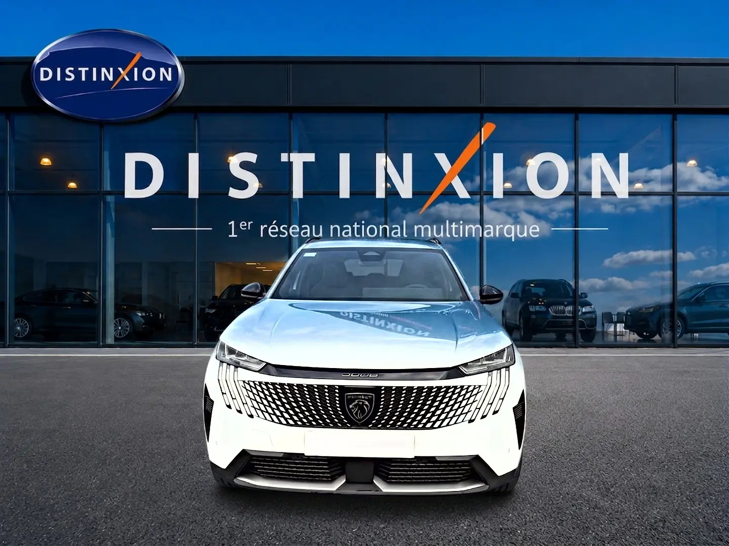 Vue frontale d'un Peugeot 5008 blanc garé devant une vitrine avec logo Distinxion en arrière-plan.