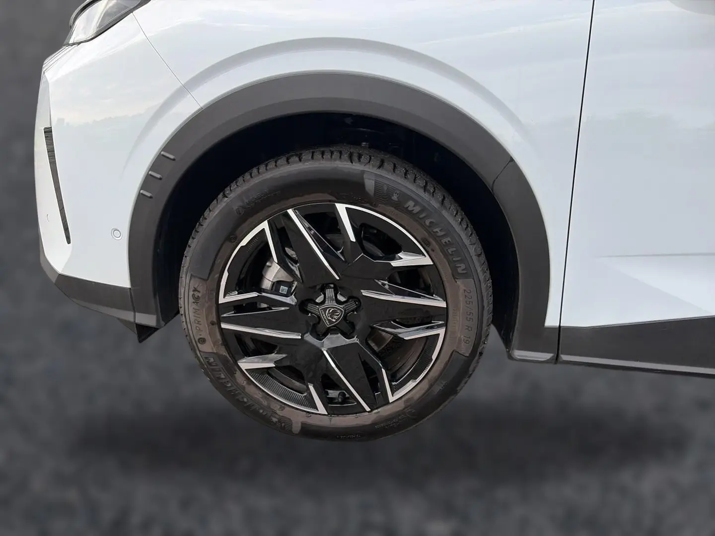 Gros plan sur la roue avant droite et l'aile blanche d'un Peugeot 5008 Hybrid 145 allure e-dcs6 2025.