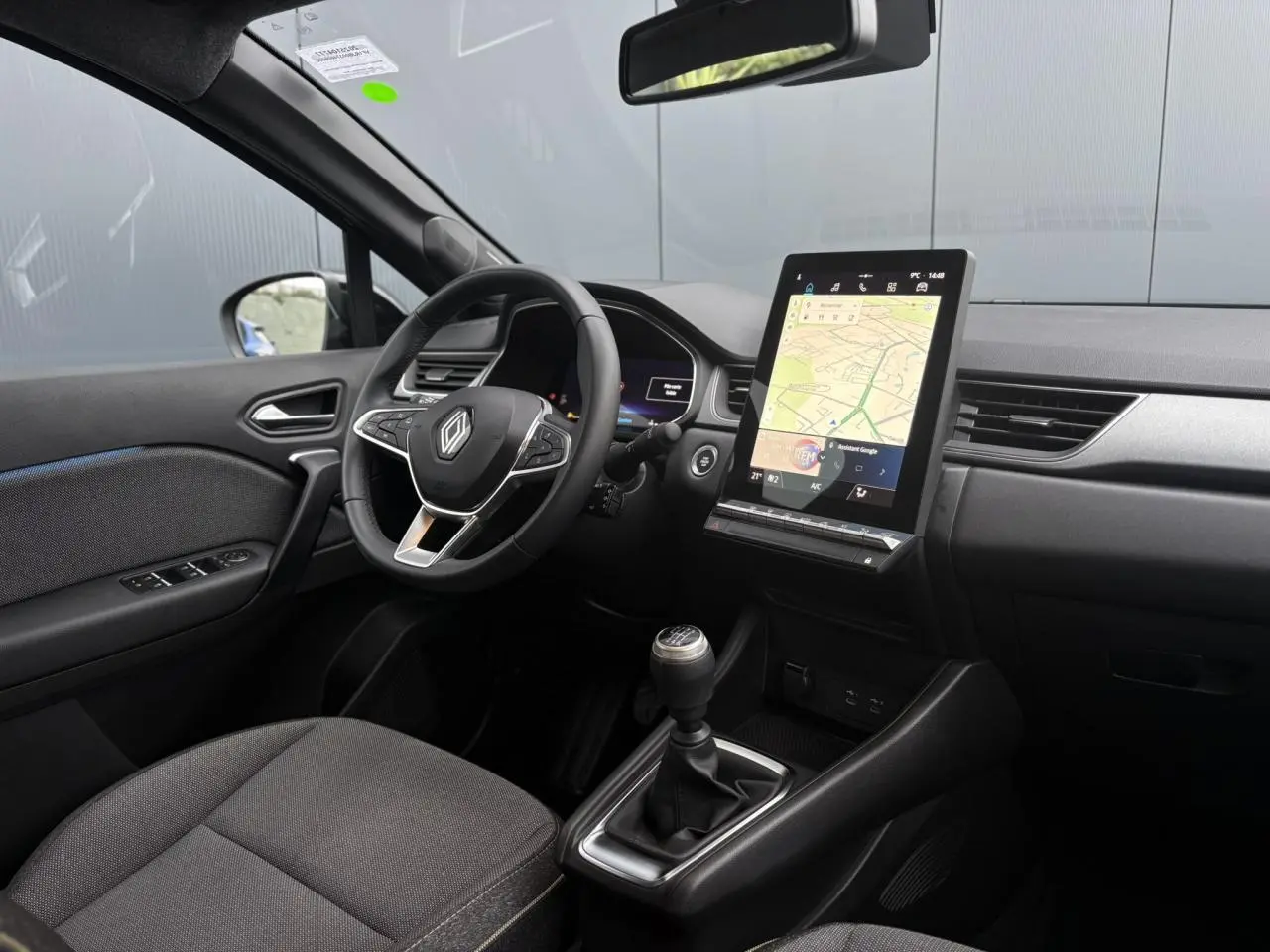 Intérieur avant du Renault Captur TCE 100 Techno 2025, vue côté conducteur, tableau de bord numérique et écran tactile GPS vertical.