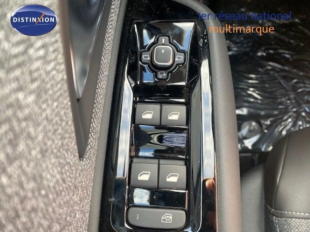 Vue rapprochée sur les commandes de lève-vitres côté conducteur du Citroën C5 X gris Thorium 2023.