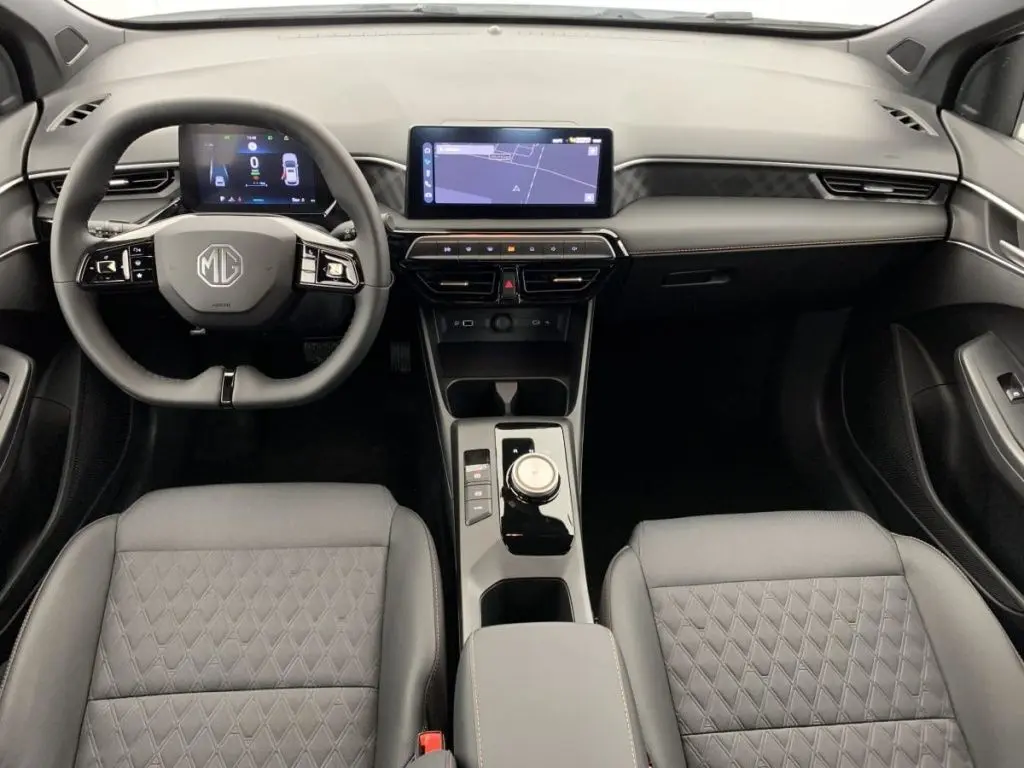 Vue intérieure avant du MG3 2025 avec tableau de bord moderne, écran tactile central et sièges cuir gris à surpiqûres losanges.