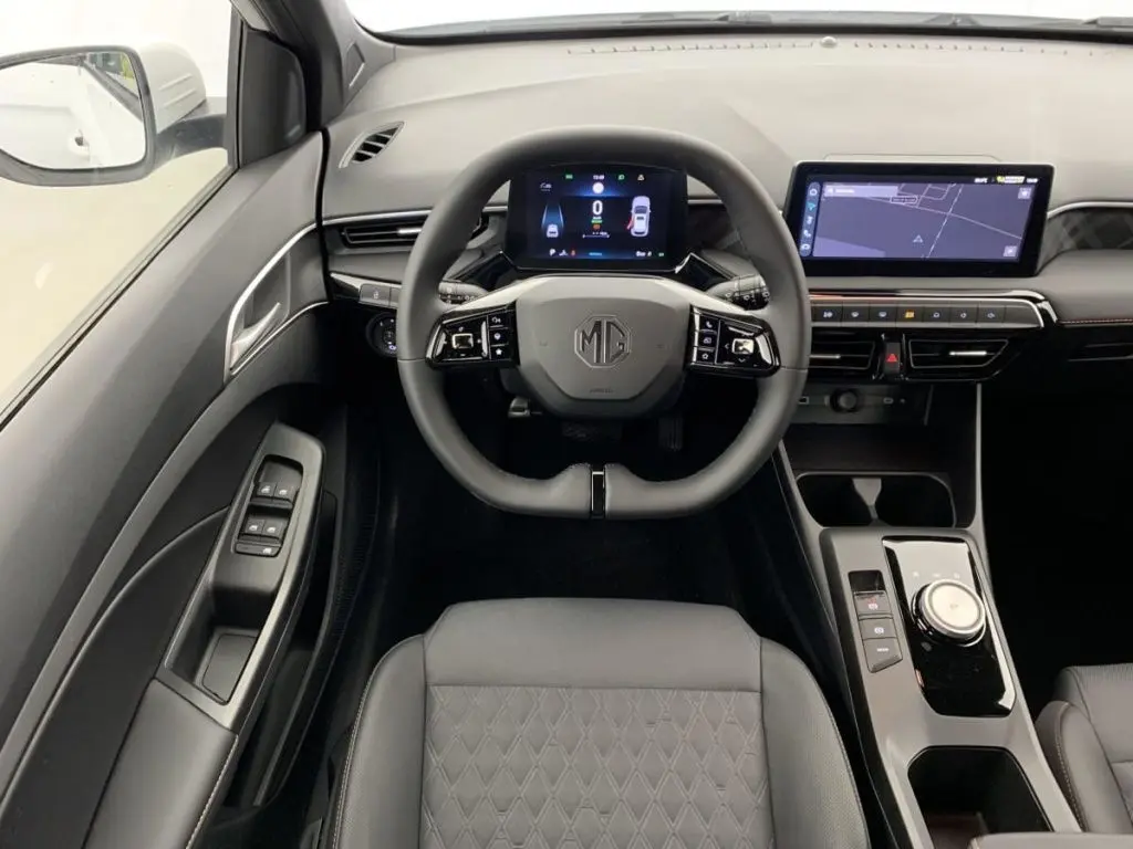 Vue intérieure centrée sur le volant MG d'une MG3 2025, avec tableau de bord numérique et écran tactile moderne.