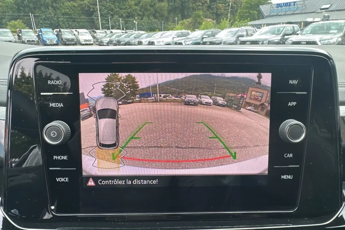 Écran de caméra de recul du Volkswagen T-Roc gris pyrite 2025, vue arrière avec lignes d’aide au stationnement.