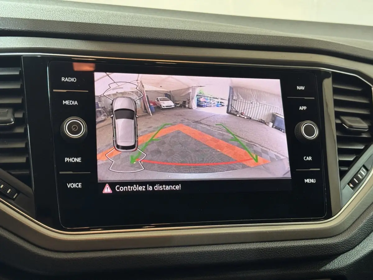 Écran tactile intérieur du Volkswagen T-Roc gris foncé montrant la caméra de recul avec guidage de trajectoire.