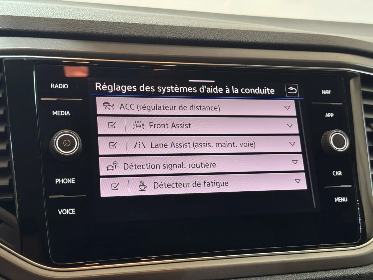 Écran tactile central du Volkswagen T-Roc 2021 affichant les réglages des aides à la conduite.