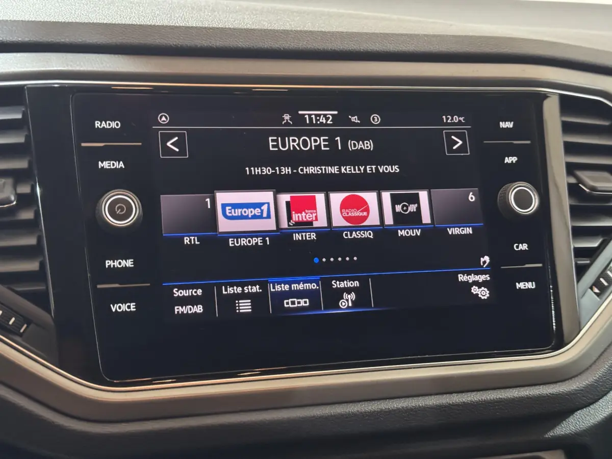 Écran tactile central du tableau de bord du Volkswagen T-Roc 1.6 TDI 115 Lounge Business, affichant les stations radio.