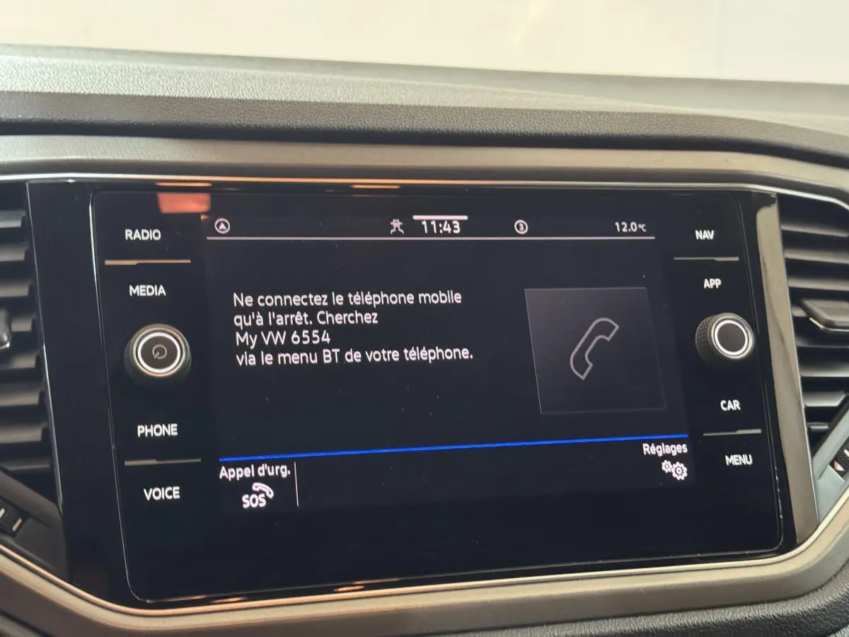 Écran tactile central du Volkswagen T-Roc gris foncé, affichant la connexion Bluetooth au téléphone.