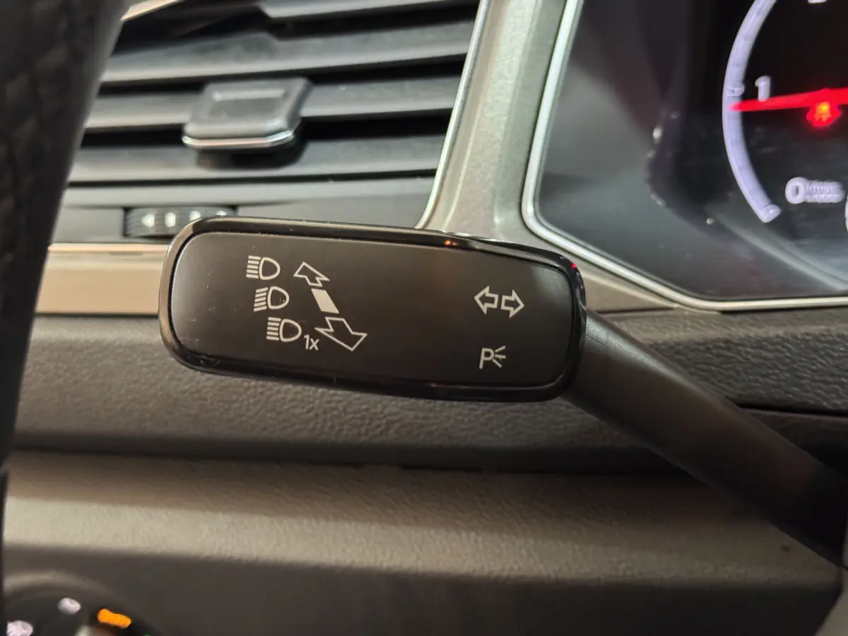 Gros plan sur la commande des feux et clignotants du Volkswagen T-Roc 1.6 TDI gris foncé, intérieur tableau de bord.