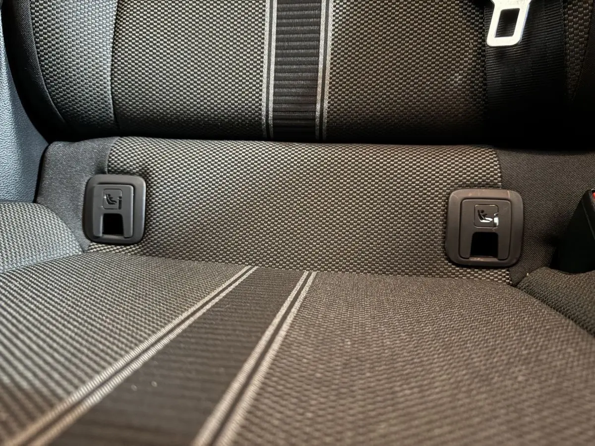 Gros plan sur la banquette arrière en tissu gris foncé du Volkswagen T-Roc 1.6 TDI 115 Lounge Business, avec attaches Isofix visibles.
