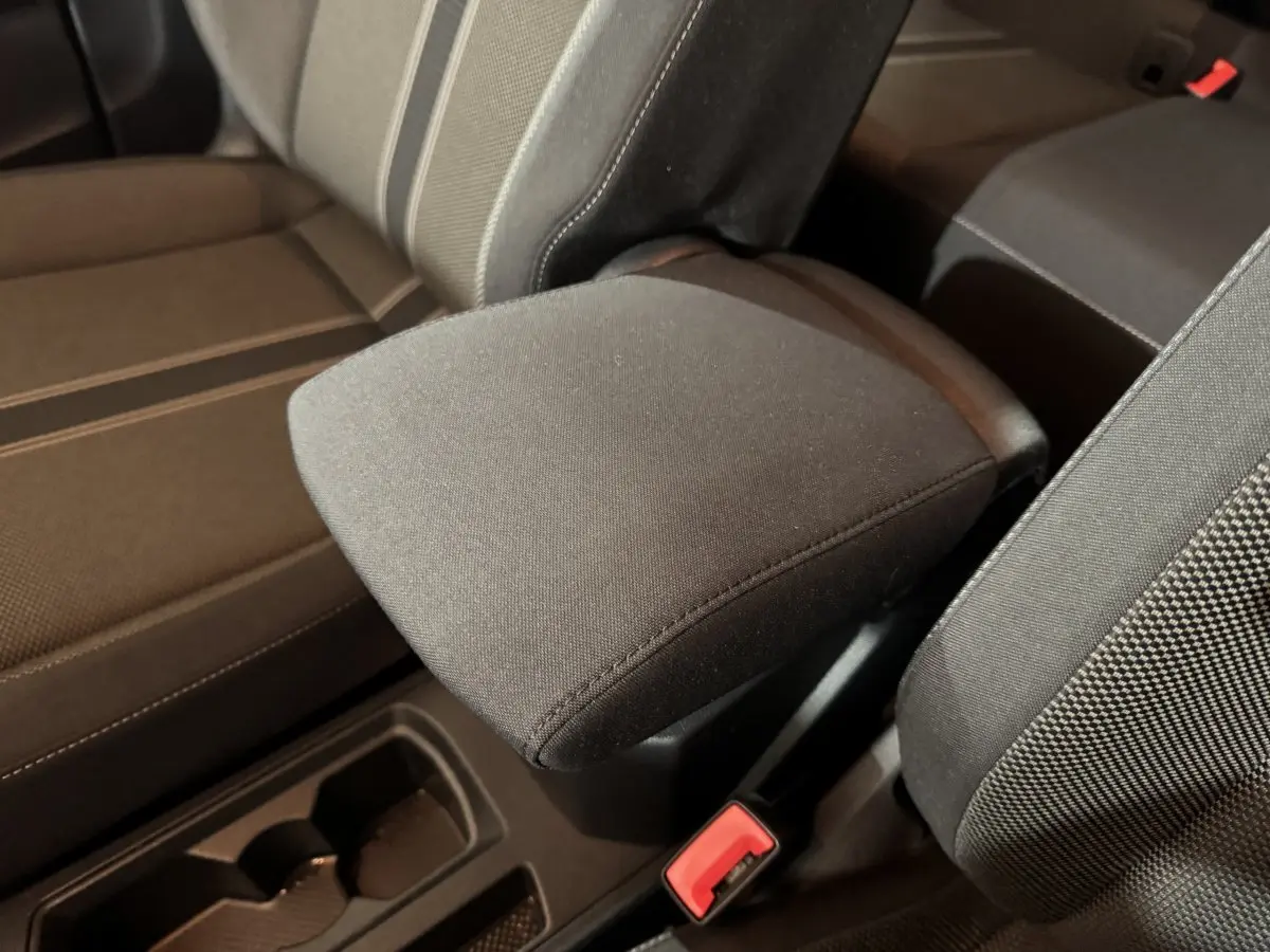 Gros plan sur l’accoudoir central tissu gris foncé entre les sièges avant du Volkswagen T-Roc 1.6 TDI 115 Lounge Business.