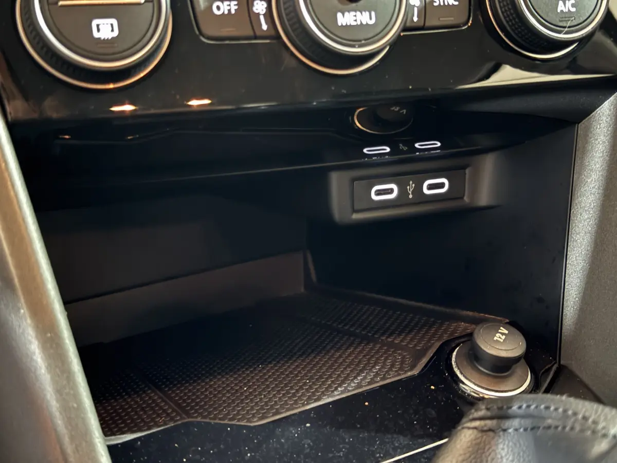 Vue rapprochée de la console centrale du Volkswagen T-Roc gris foncé 2021, avec ports USB et prise 12V visibles.