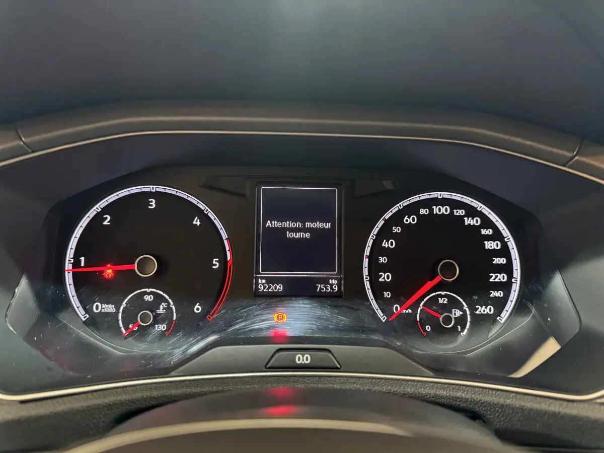 Vue rapprochée du tableau de bord du Volkswagen T-Roc gris foncé, affichant les compteurs et un message d'alerte moteur.