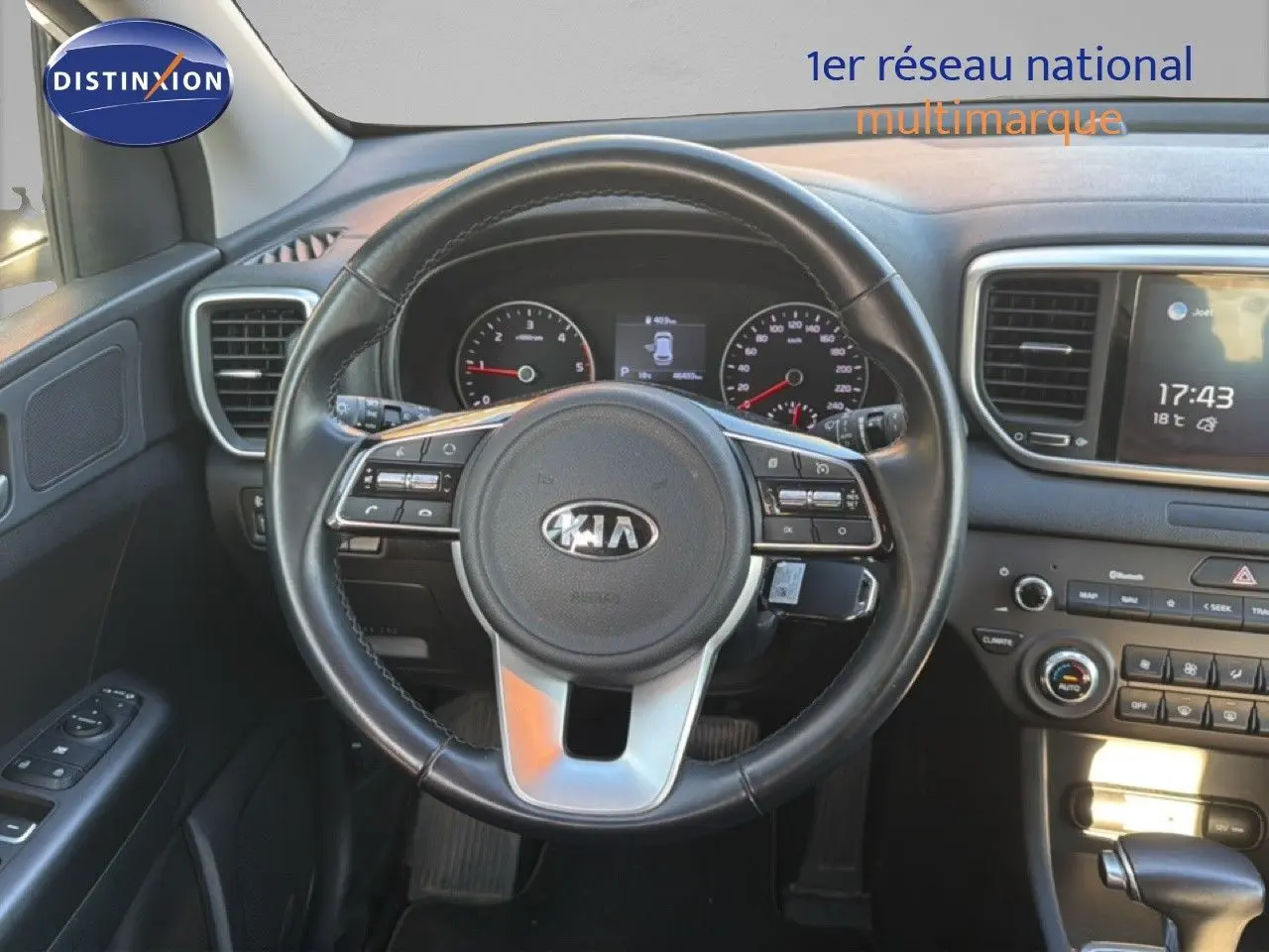 Vue intérieure centrée sur le volant noir du Kia Sportage 2021 avec tableau de bord et écran tactile visibles.