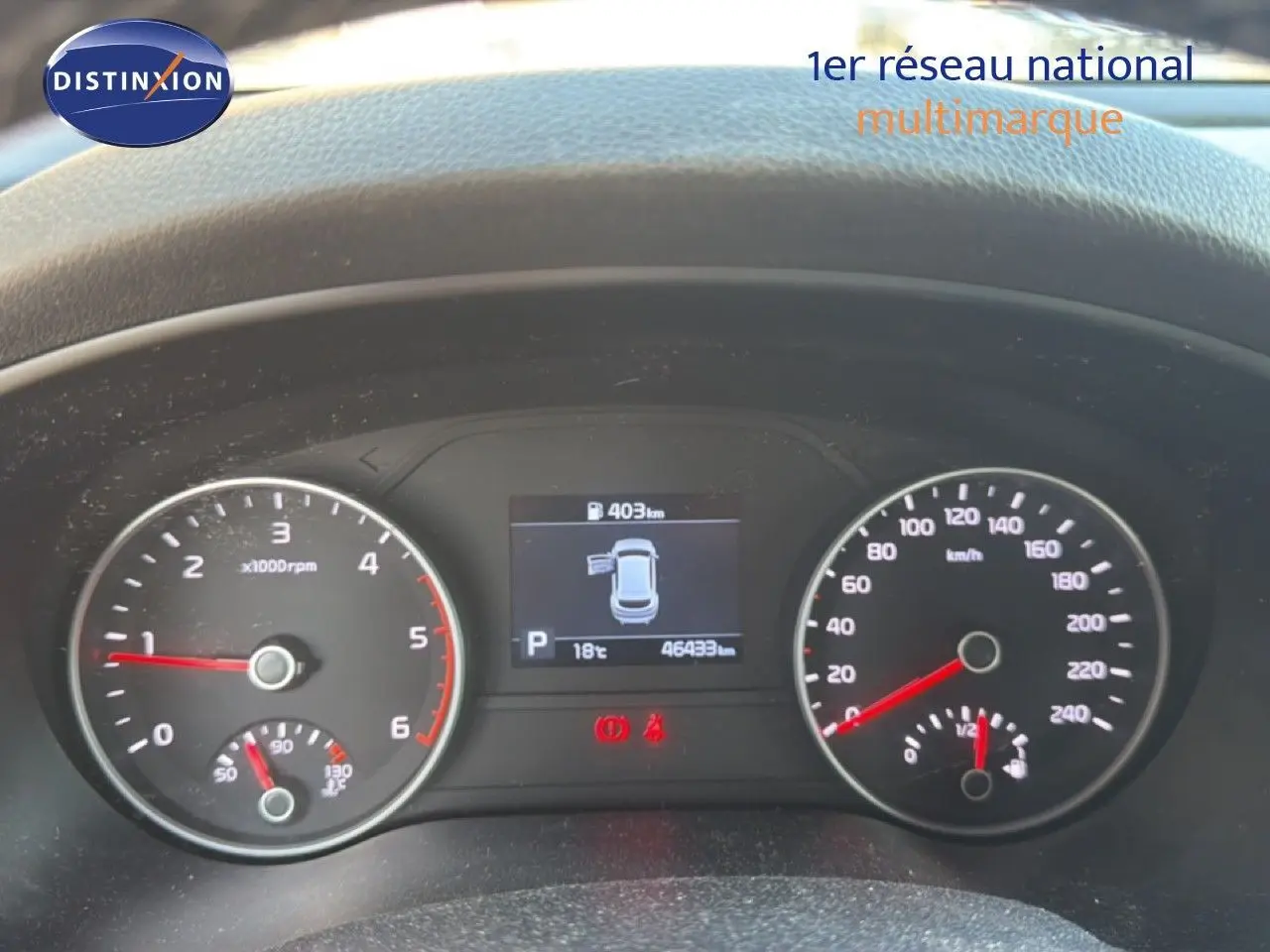 Tableau de bord du Kia Sportage blanc nacré 2021, affichant 46 433 km et jauge carburant à moitié.