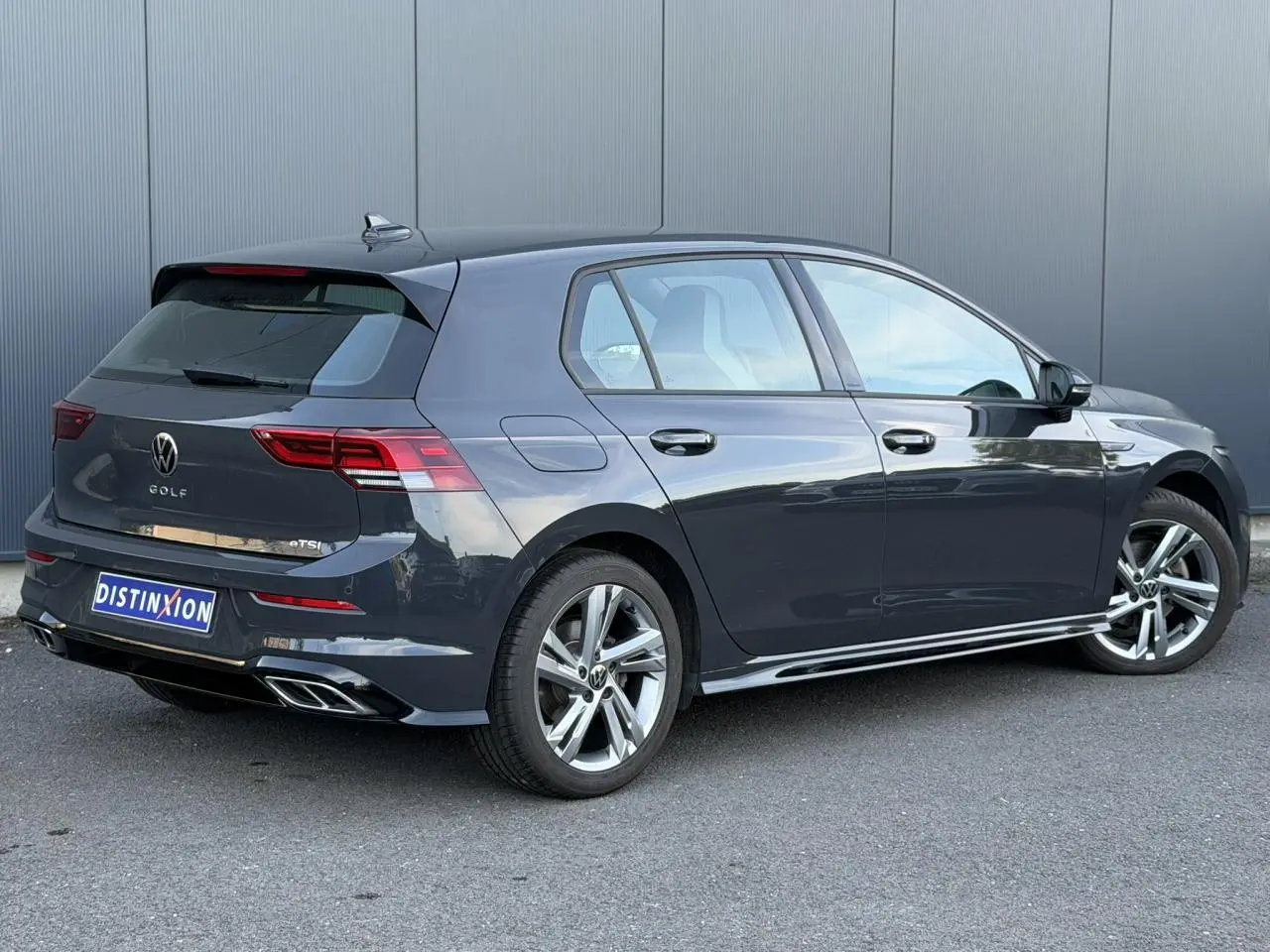 Volkswagen Golf 8 R-Line gris Urano vue 3/4 arrière droit avec jantes alliage et feux LED arrière.