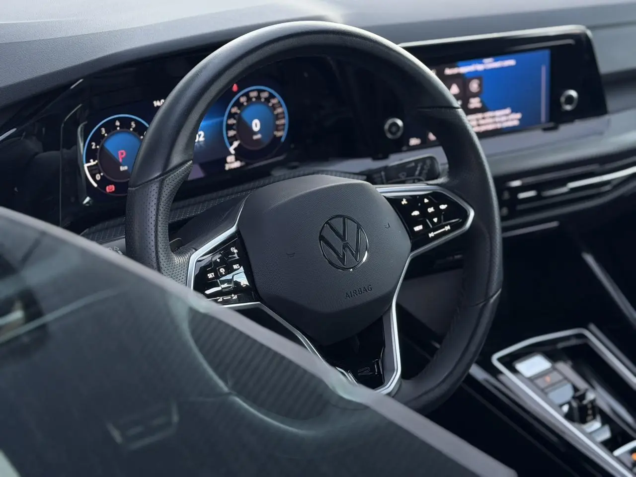 Vue rapprochée du volant cuir multifonction noir et du tableau de bord digital de la Volkswagen Golf 8 R-Line 2024.