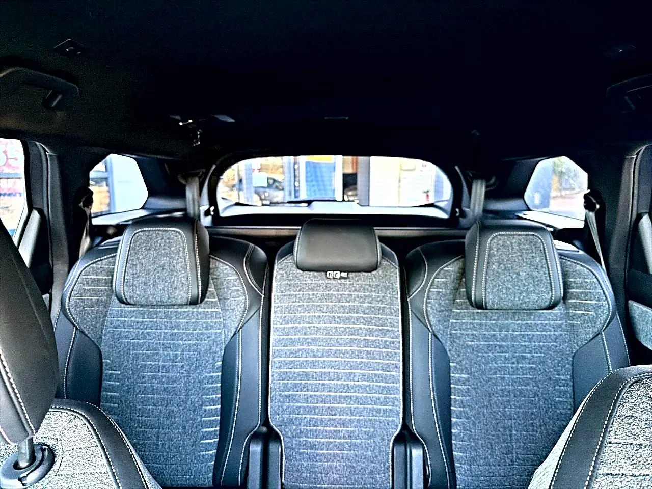 Vue intérieure arrière des sièges gris tissu crispy et tep isabella du Peugeot 5008 Hybrid 145 allure e-dcs6 2025.
