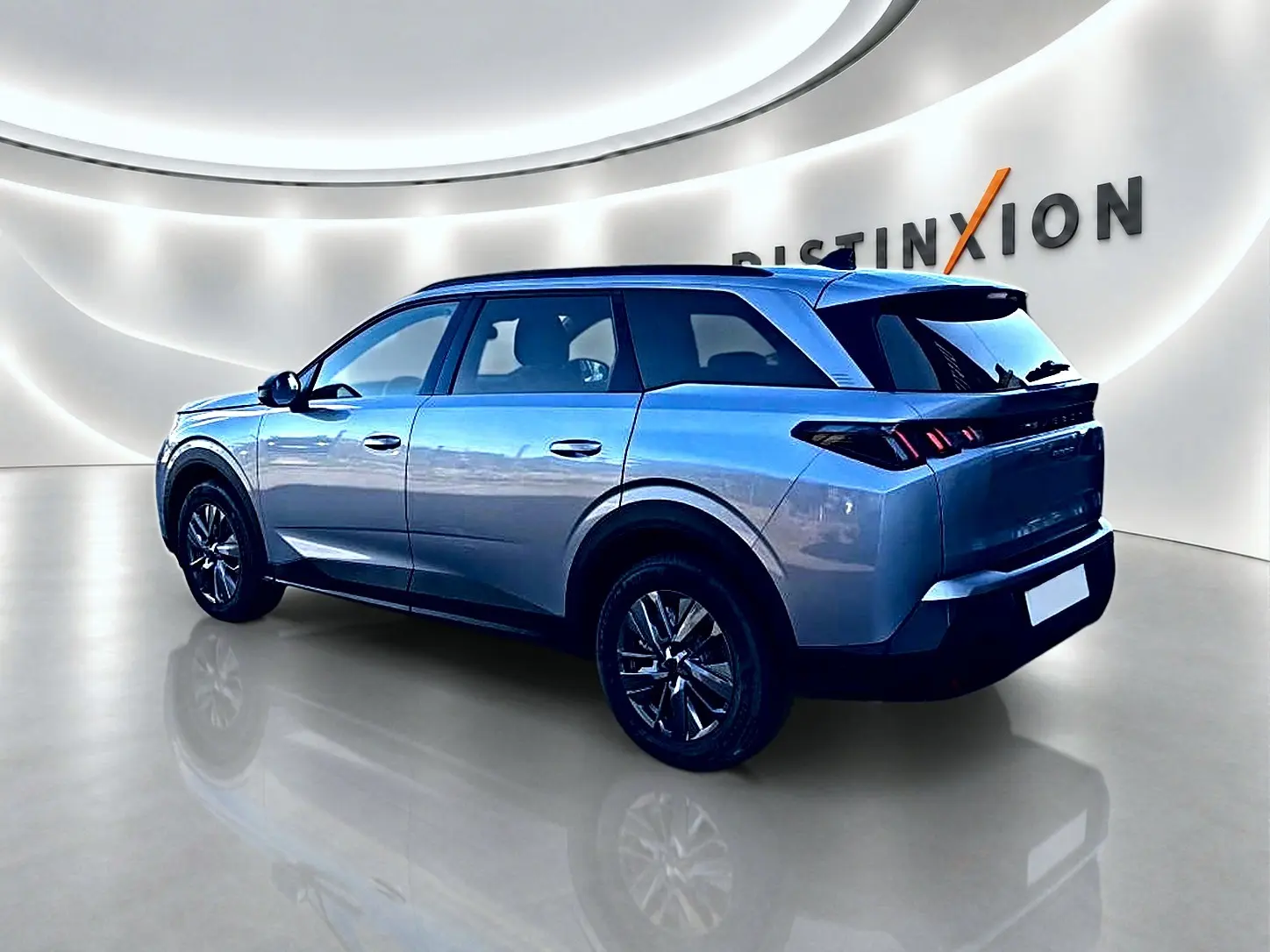 Peugeot 5008 gris Artense en vue 3/4 arrière droit, avec jantes alu et feux arrière LED distinctifs.
