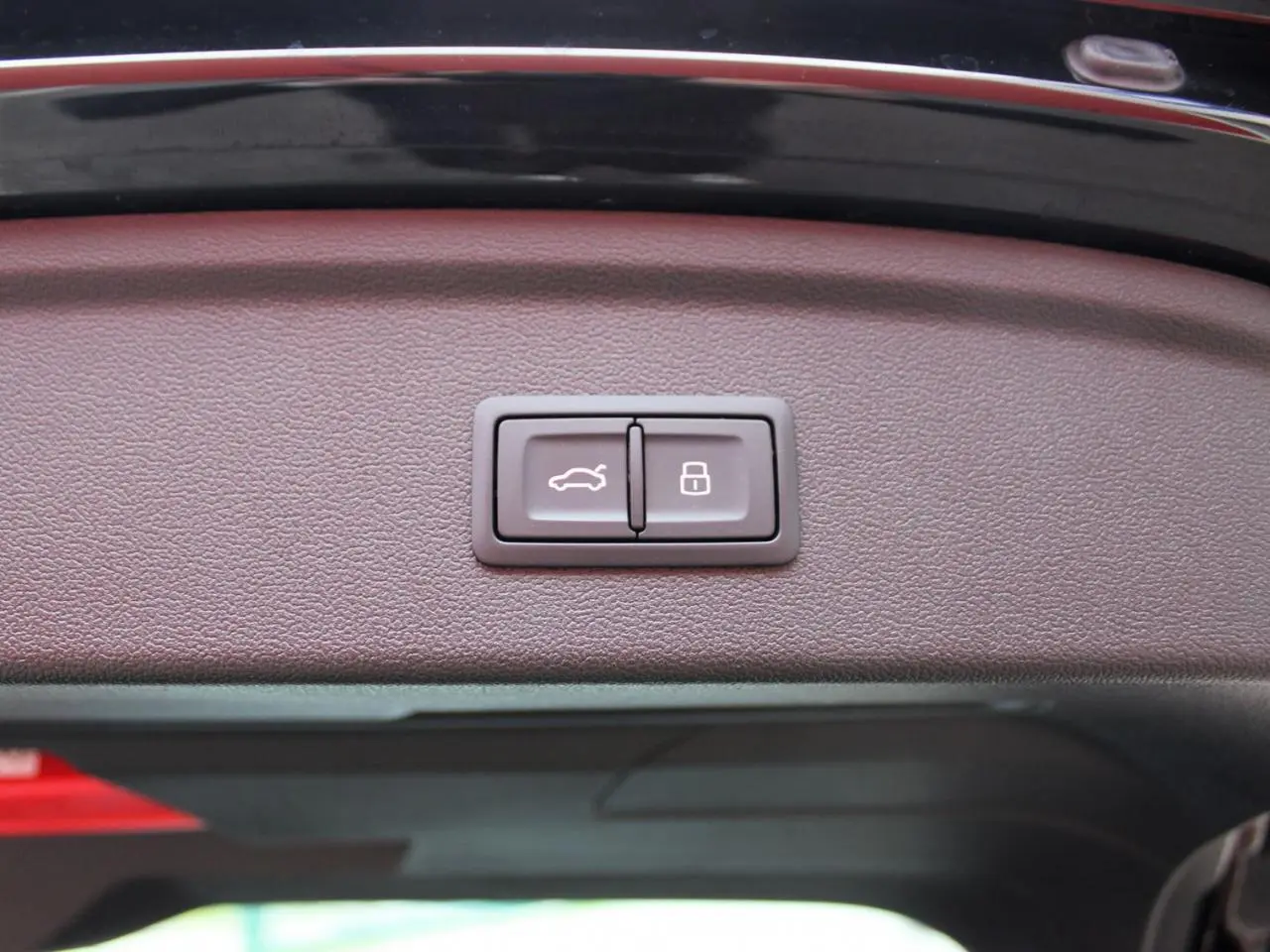 Gros plan sur les boutons d'ouverture et de verrouillage du hayon électrique de l'Audi A3 Sportback noir Mito Metal.