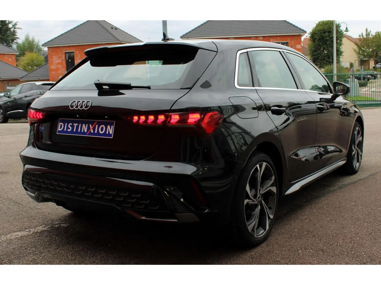 Audi A3 Sportback noir mito métal vue 3/4 arrière droit avec feux arrière LED et jantes alliage 18 pouces.
