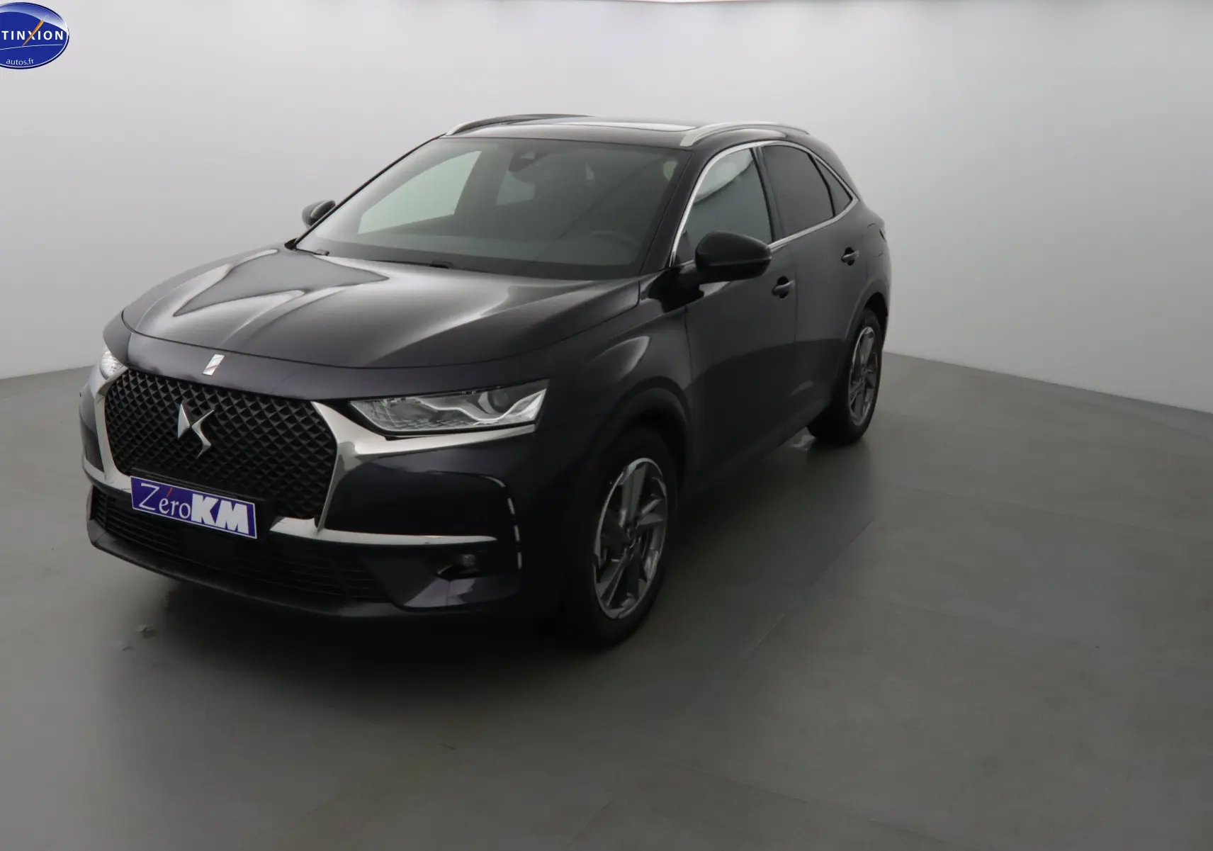 DS7 Crossback hybride rechargeable bleu encre métal vu en 3/4 avant droit avec calandre DS distinctive.