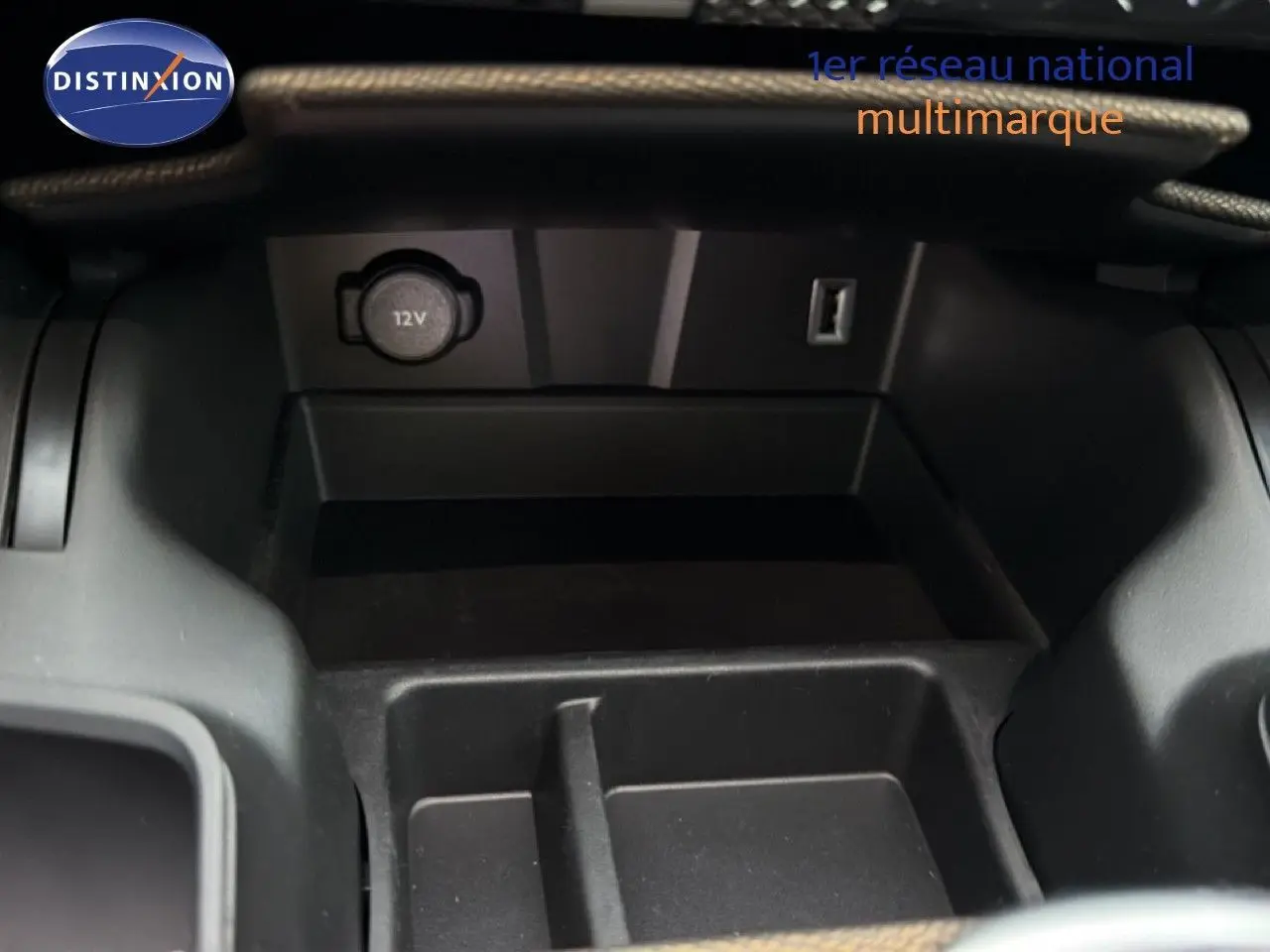 Gros plan sur la console centrale du DS7 Crossback bleu encre, montrant une prise 12V et un port USB.