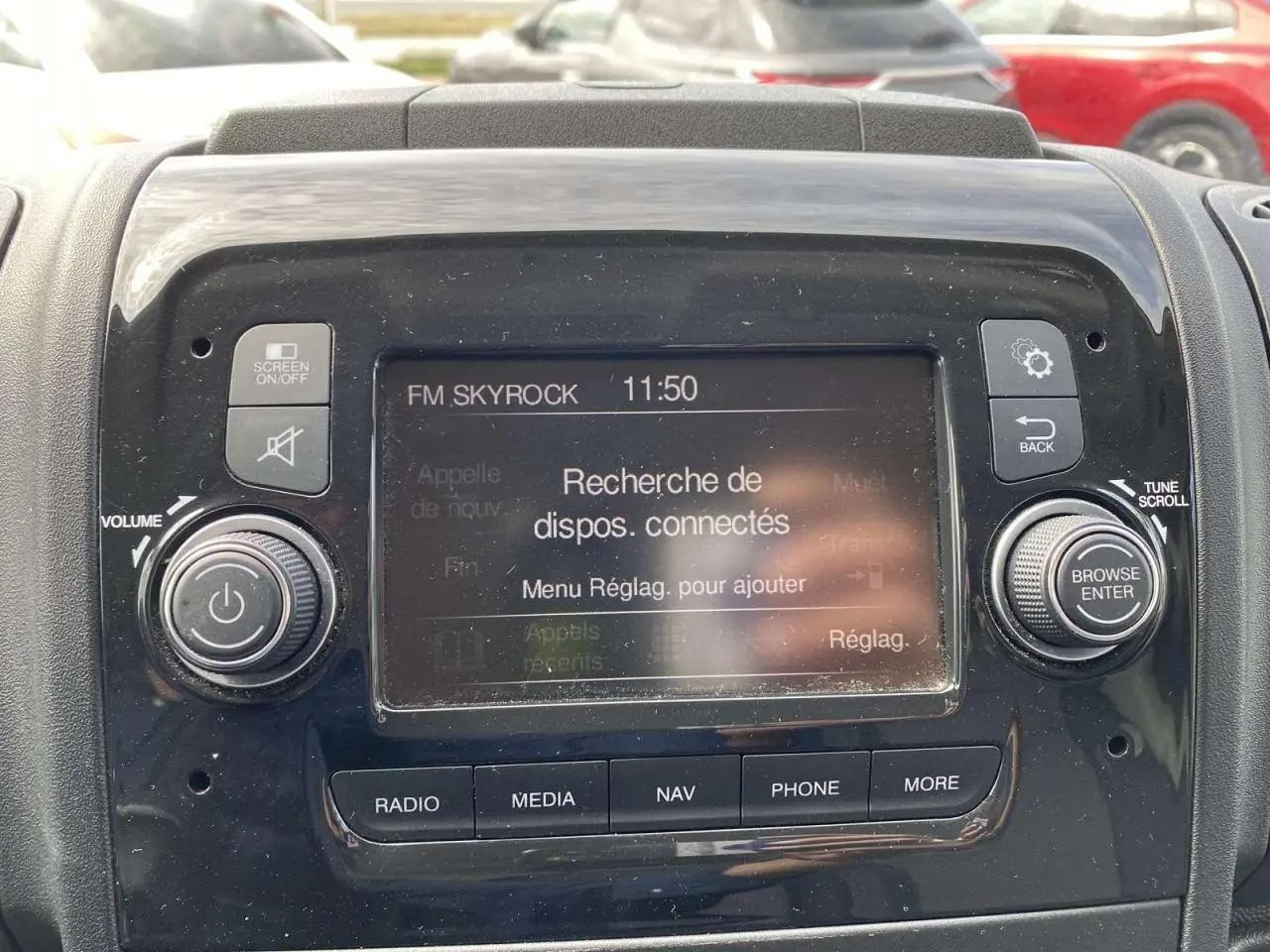 Gros plan sur l'écran tactile central du tableau de bord de l'Opel Movano Fourgon blanc, affichant la recherche de dispositifs connectés.