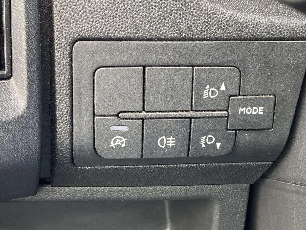 Gros plan sur les commandes d'éclairage et mode du tableau de bord du fourgon blanc Opel Movano 3.5T L2H2 2022.