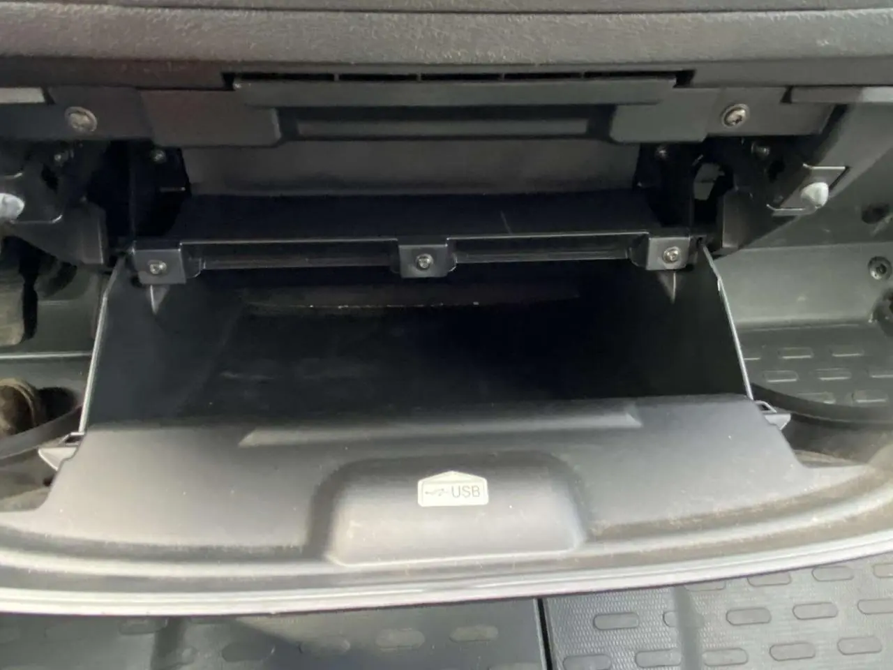 Gros plan sur la boîte à gants ouverte avec port USB visible dans l'Opel Movano Fourgon blanc de 2022.