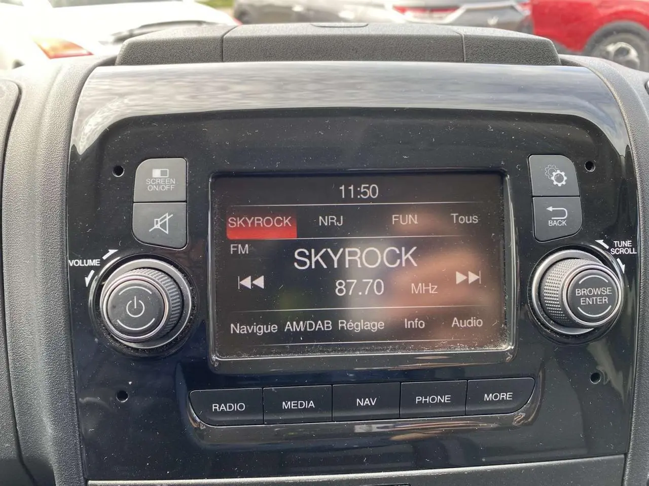 Écran central de la radio numérique du fourgon Opel Movano blanc, affichant la station Skyrock à 87,7 MHz.