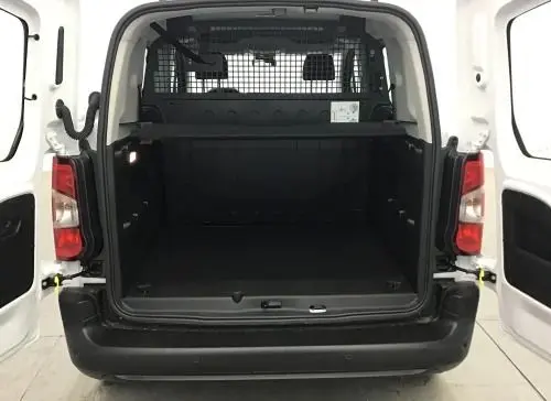 Vue arrière ouverte du Peugeot Rifter blanc Banquise 2025, montrant l’espace de chargement avec cloison de sécurité métallique.