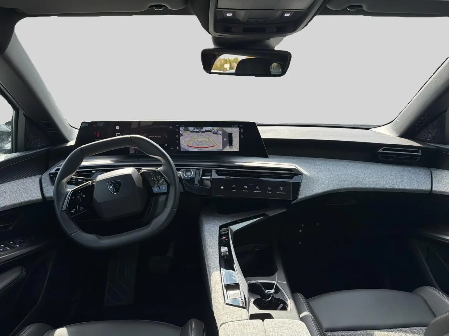 Vue intérieure avant du Peugeot 5008 blanc 2025, tableau de bord moderne avec écran tactile panoramique et volant cuir multifonction.