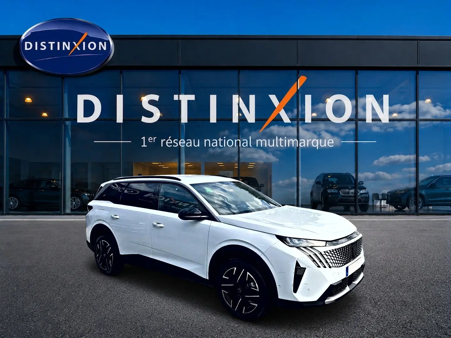 Peugeot 5008 blanc en vue 3/4 avant droit, avec jantes noires et toit noir, devant un showroom Distinxion.