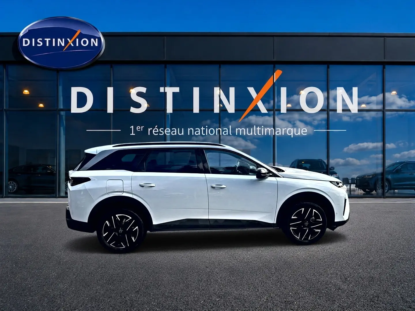 Peugeot 5008 Hybrid 145 allure e-dcs6 blanc vue de profil côté gauche devant une vitrine Distinxion.