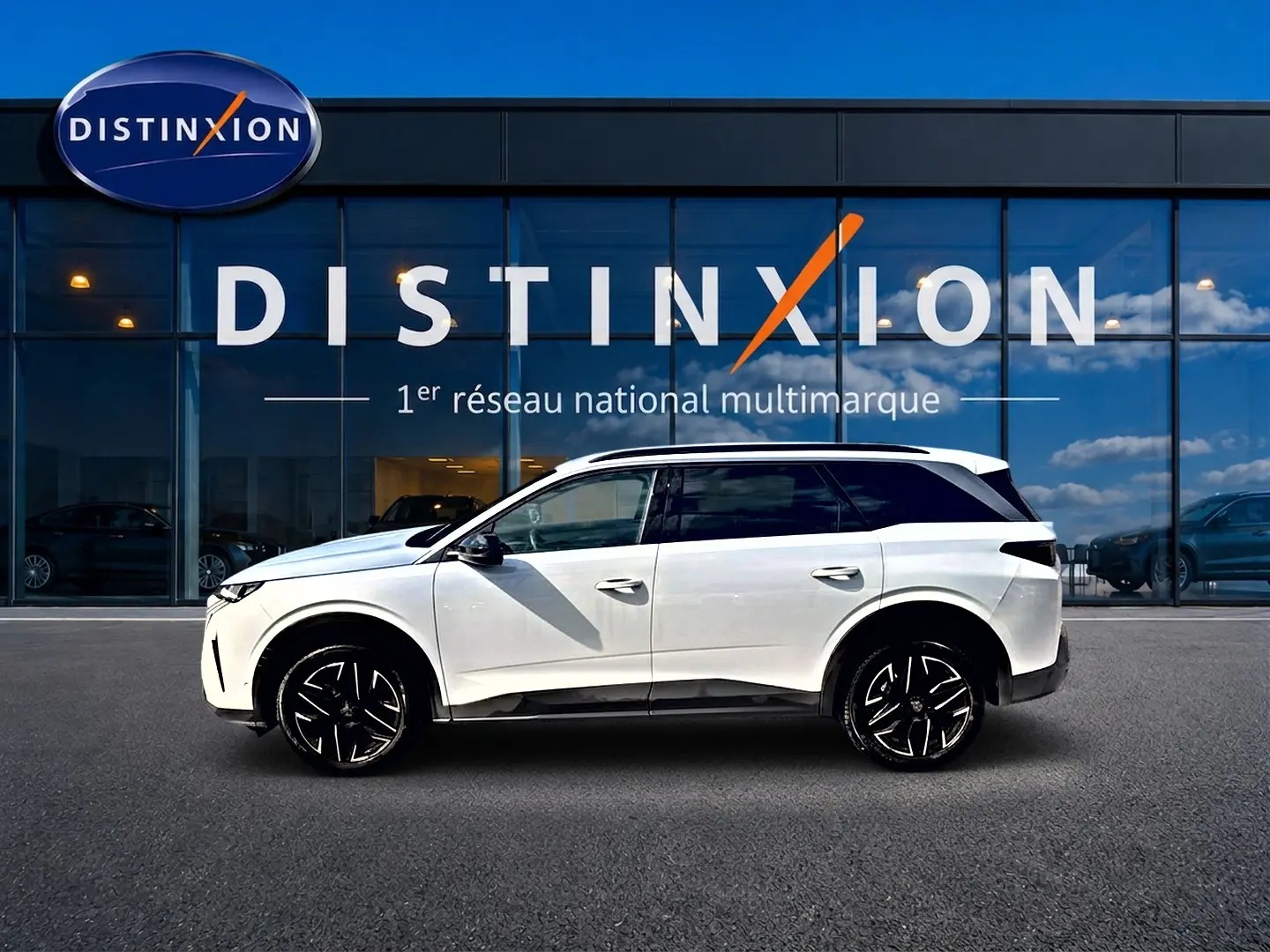 Peugeot 5008 Hybrid 145 allure e-dcs6 blanc vue de profil côté gauche devant un showroom Distinxion.