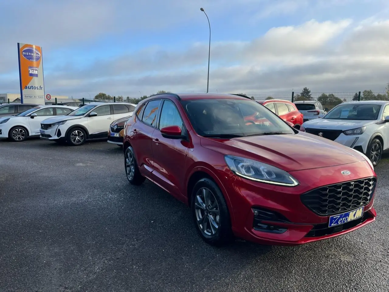Ford Kuga 1.5 EcoBoost ST-Line rouge Lucifer en 3/4 avant droit, avec calandre et jantes spécifiques ST-Line visibles.