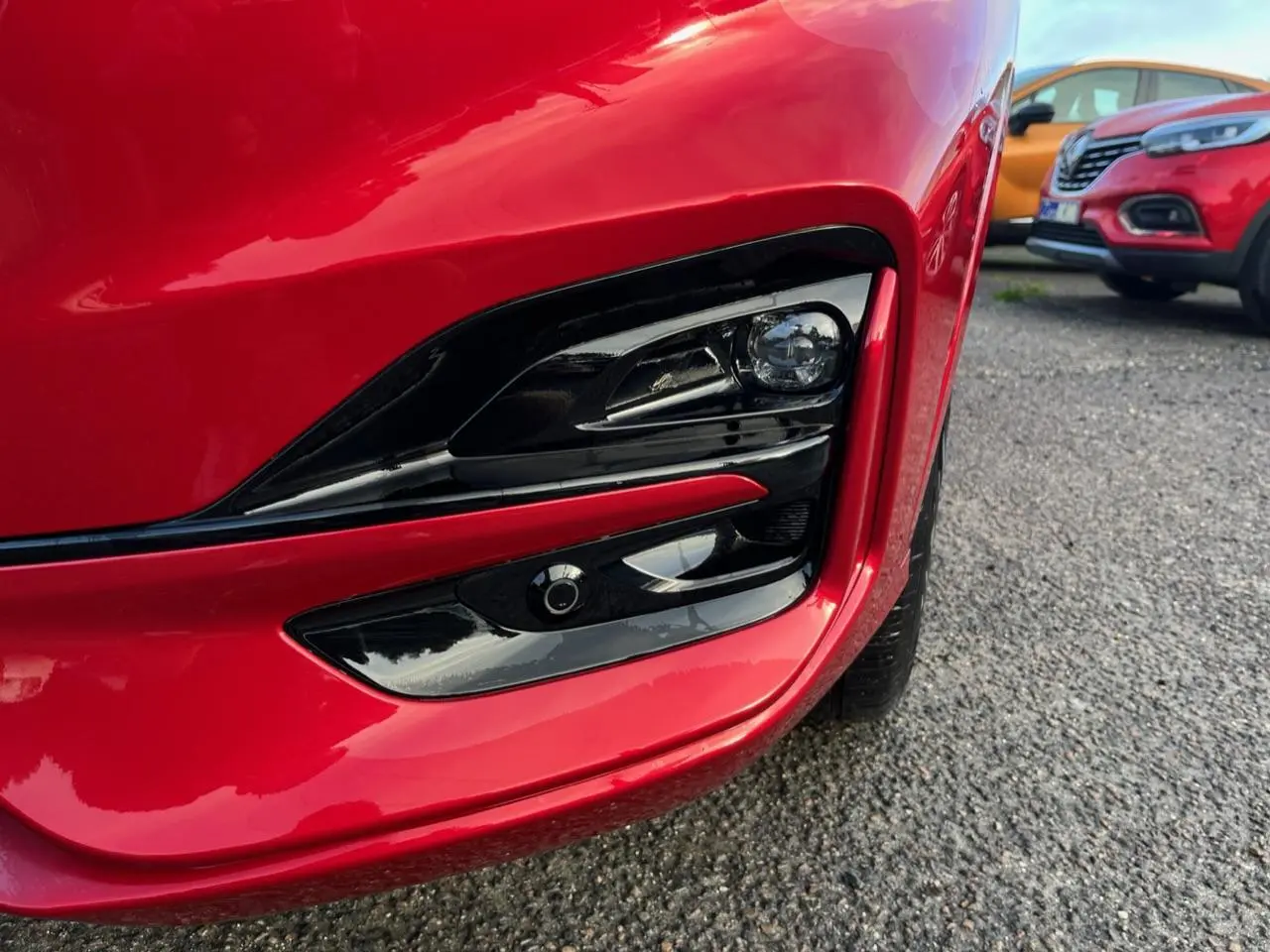 Gros plan sur le phare avant droit rouge Lucifer du Ford Kuga 1.5 EcoBoost ST-Line avec détails noirs brillants.