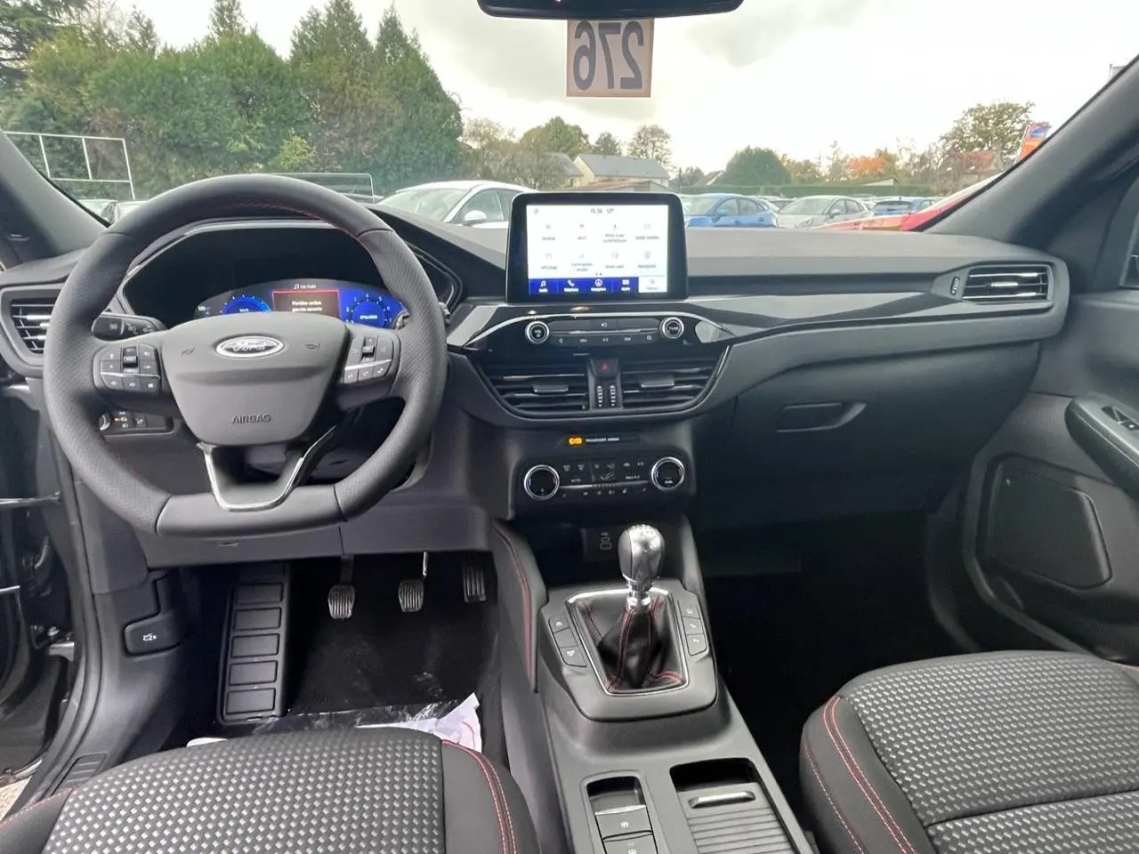 Intérieur du Ford Kuga ST-Line 2022, vue avant du tableau de bord avec volant multifonction et boîte manuelle.