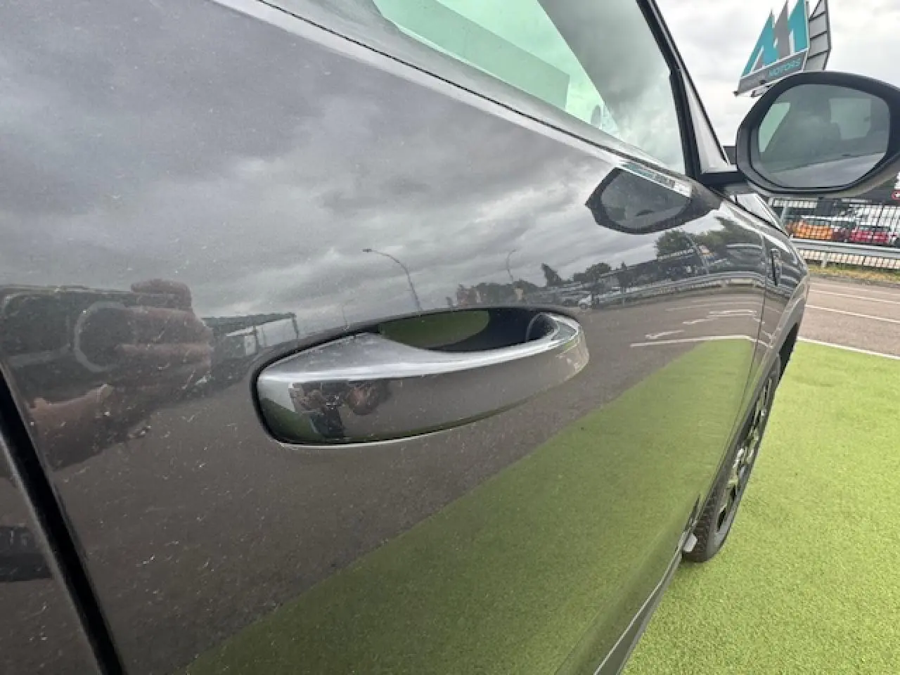 Poignée de porte côté gauche d’un Peugeot 3008 gris titane avec toit noir, vue rapprochée en extérieur.