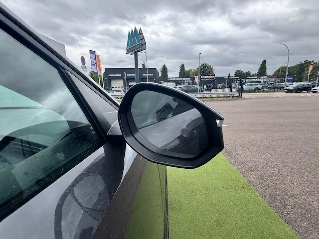 Rétroviseur côté gauche d’un Peugeot 3008 gris titane avec toit noir, vue rapprochée en extérieur.