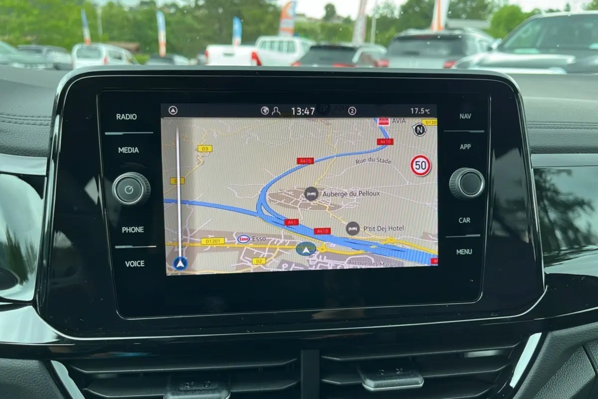 Écran tactile central du Volkswagen T-Roc gris indium 2025 affichant la navigation GPS en plein jour.