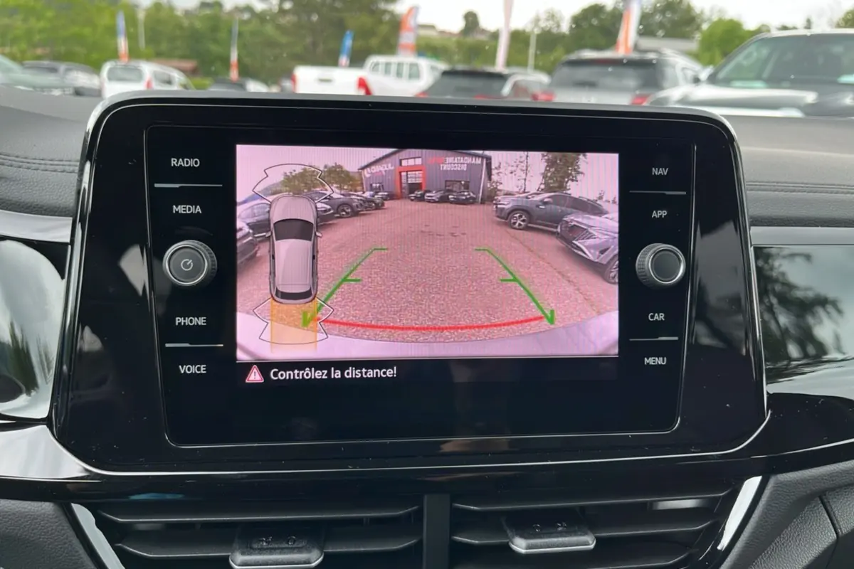 Écran central affichant la caméra de recul du Volkswagen T-Roc gris indium, vue arrière avec guidage de trajectoire.