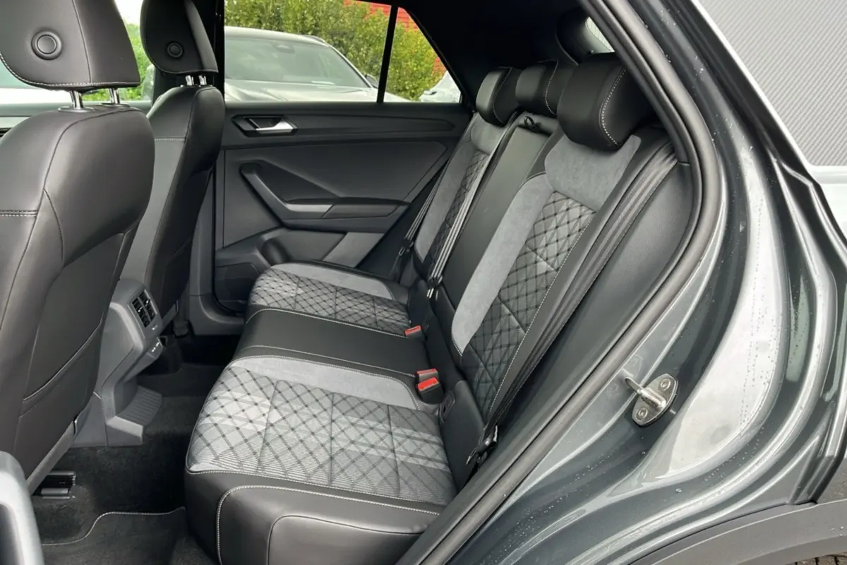 Vue intérieure côté droit des sièges arrière du Volkswagen T-Roc gris indium avec sellerie mixte tissu et cuir noir.