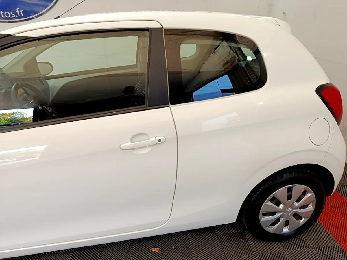 Vue latérale droite d'une Citroën C1 blanche de 2020, mettant en valeur la porte et la roue arrière.