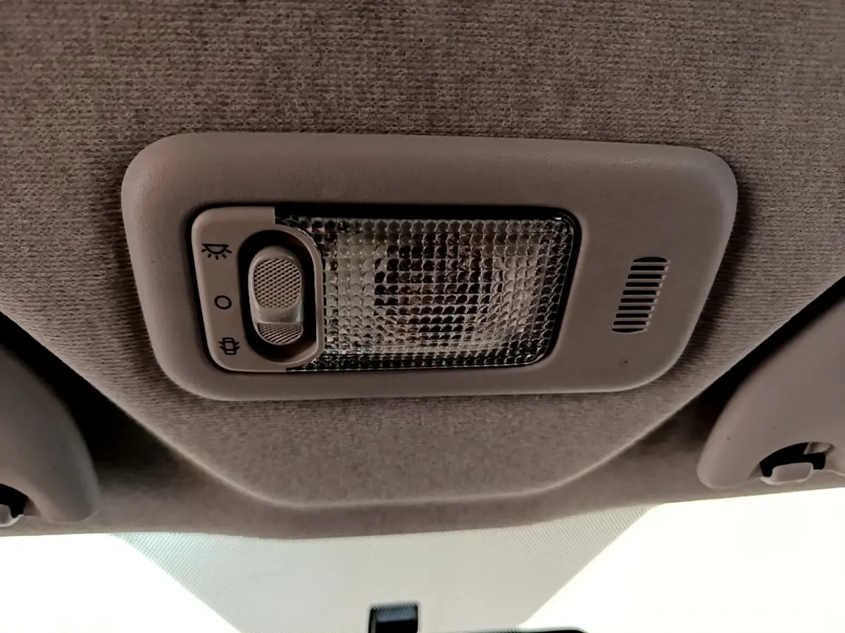 Plafonnier intérieur gris avec interrupteur de lumière, situé au centre du toit d'une Citroën C1 blanche de 2020.