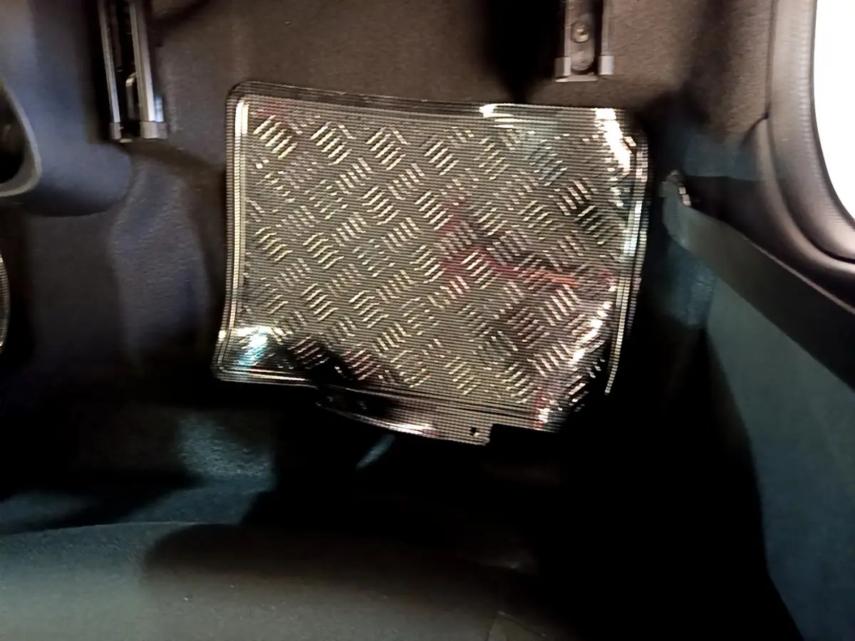 Détail du tapis de sol en caoutchouc noir à motif sur le côté gauche intérieur d'une Citroën C1 blanche.