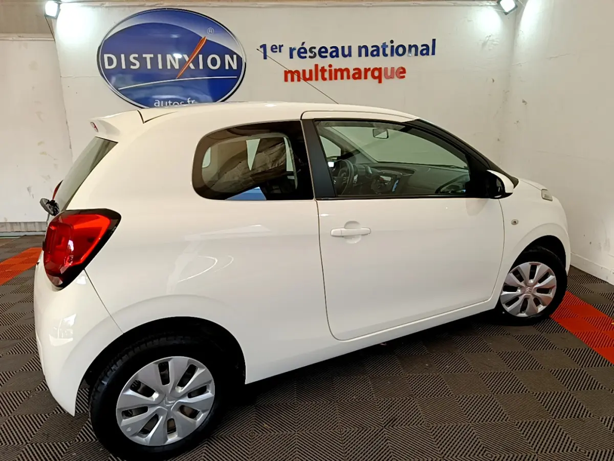 Vue latérale droite d'une Citroën C1 blanche de 2020, compacte, avec jantes en alliage et vitres teintées.