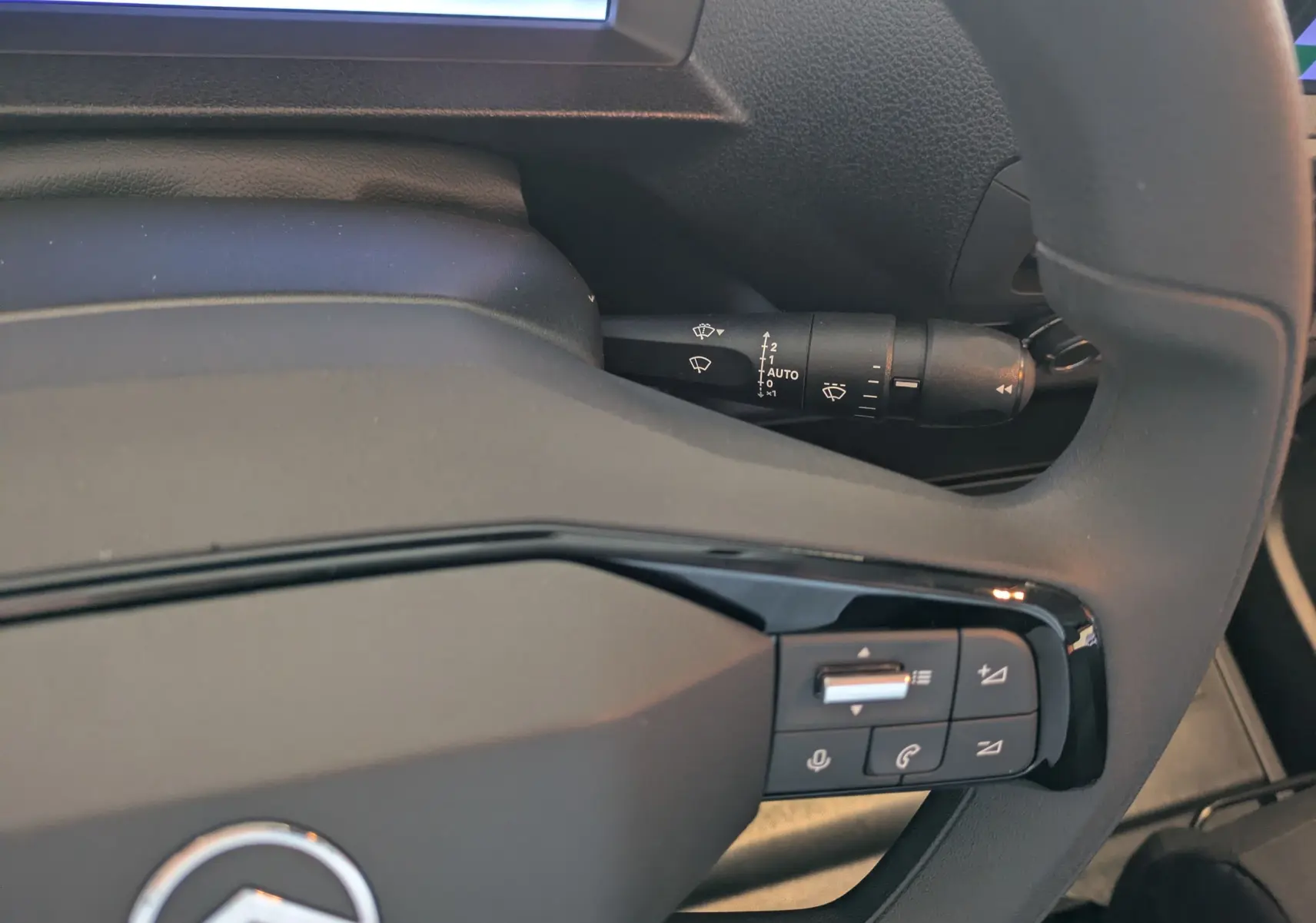 Gros plan sur le volant noir du Citroën Jumpy XL 2025 avec commandes audio et manette d’essuie-glace visible.