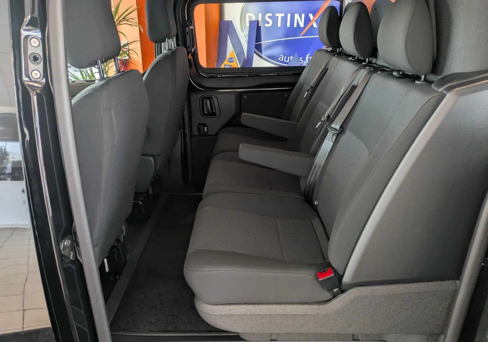 Vue intérieure côté gauche des sièges arrière noirs du Citroën Jumpy Cabine Approfondie XL 2025 avec accoudoirs déployés.
