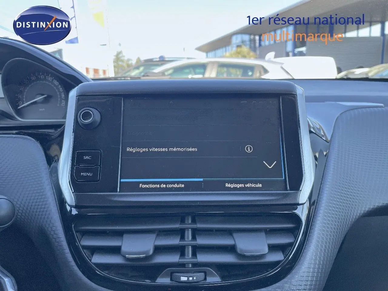 Vue rapprochée de la console centrale tactile du Peugeot 2008 blanc, affichant les réglages de vitesses mémorisées.